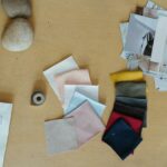 An overhead view of a creative workspace featuring fabric swatches and design photographs.